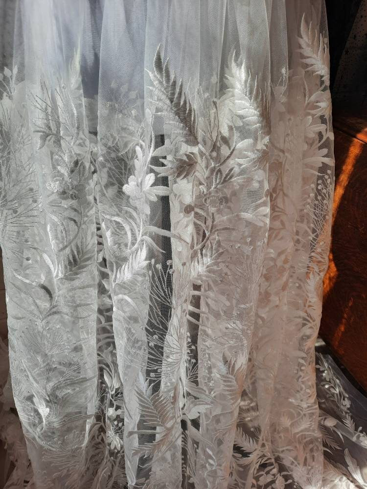 Floral bridal overskirt in off-white. Embroidered tulle with trailing flowers and leaves, perfect for a winter wedding.